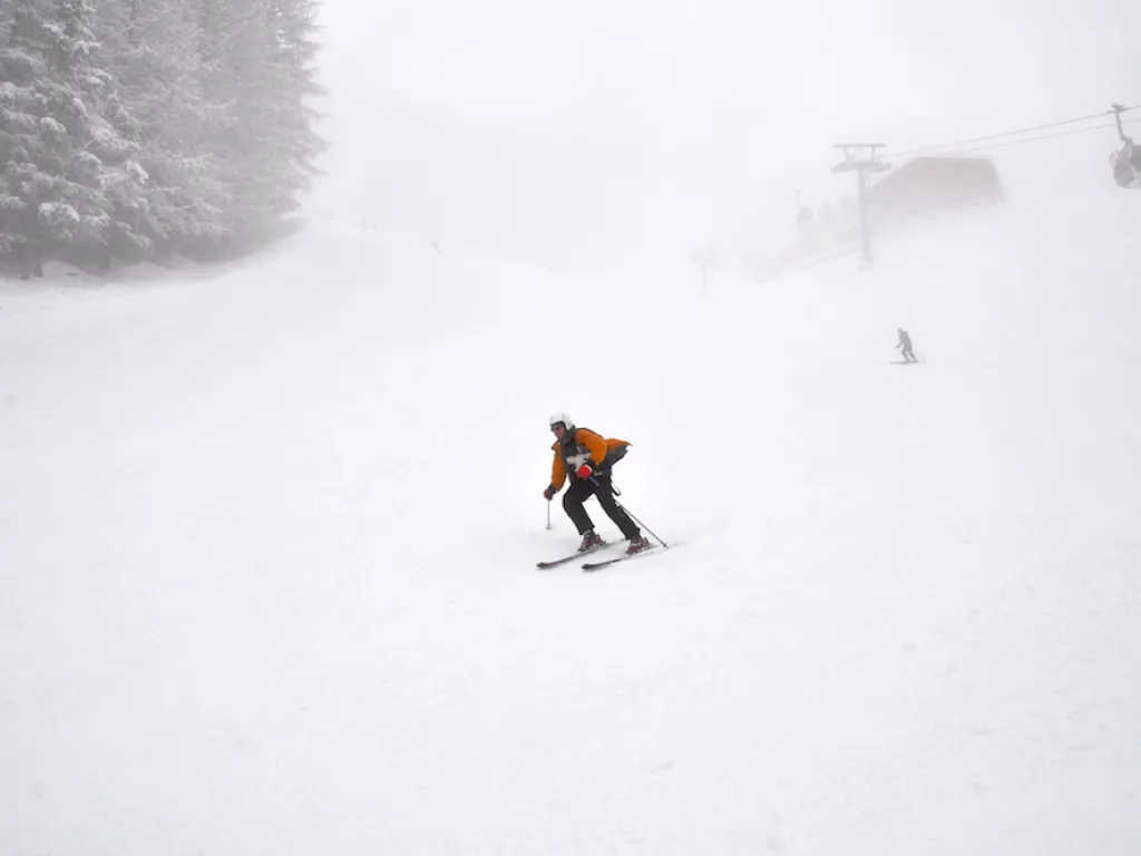 Skifahrer fährt allein durch den Nebel.